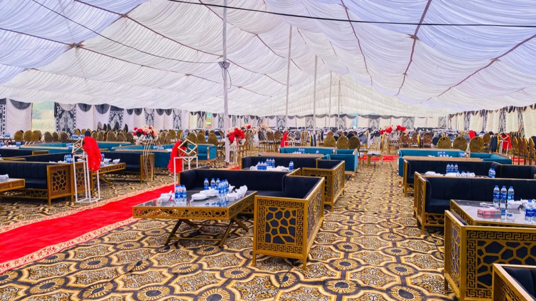 Full wedding reception and dining hall setup with gold-frame sofas by Events by Momin, event planner in Khanpur